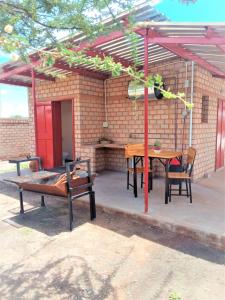 a patio with a table and chairs and a building at Stop 'n Stay Otavi Rest Camp in Otavi