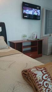 1 dormitorio con 1 cama y TV en la pared en Seribu 1 Homestay Single Room en Kundasang