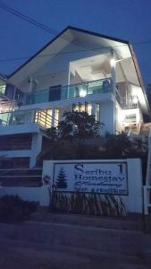 a large white house with a sign in front of it at Seribu 1 Homestay Single Room in Kundasang