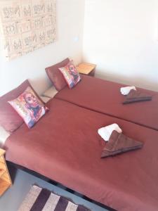 two beds in a room with red sheets and pillows at Stop 'n Stay Otavi Rest Camp in Otavi