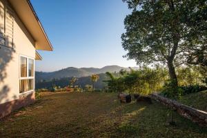 une maison avec une cour offrant une vue sur les montagnes dans l'établissement Vaga Roville- Tea Plantation Valley View by StayVista, à Vagamon