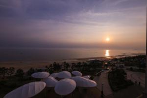 Merrymud Hotel في بوريونغ: مجموعة من المظلات البيضاء أمام الشاطئ