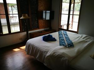a bedroom with a bed with a blue robe on it at River Marina Resort in Uthai Thani