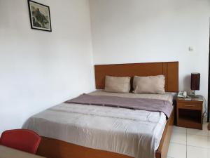 - une chambre avec un lit et une table de chevet dans l'établissement OYO 2991 Satya Homestay, à Makassar