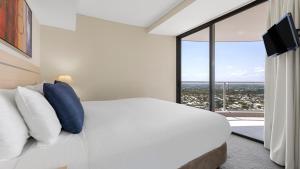 Oaks Brisbane Aurora Suites客房内的一张或多张床位