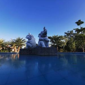 a statue of two elephants in a pool of water at บ้านสวนกรีนวิวรีสอร์ท in Khon Kaen