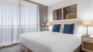 Oaks Brisbane Aurora Suites客房内的一张或多张床位