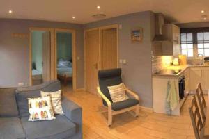 a living room with a couch and a kitchen at 41 Tudor Court in Hayle +4 photos
