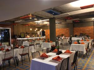 een eetkamer met witte tafels en stoelen en een keuken bij Central Corner d'Angkor in Siem Reap