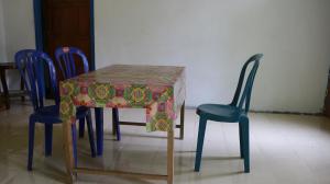 a table with two chairs and a table cloth on it at Homestay Mbah Parni in Sermo