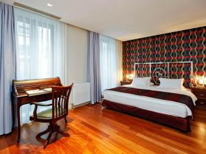 Una habitación de hotel con una cama y un escritorio y un escritorio. en Galateia Residence, en Estambul