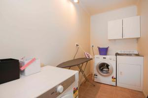 a kitchen with a washing machine and a washer at Hilltop Getaway in Nelson