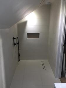 een badkamer met een douche met een licht aan de muur bij Private Double Room With New En-suite Shower Room in Kings Lynn