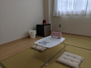 a room with a white table and two chairs at 街のホテル in Fujiyoshida