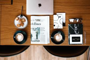 a table with a cup of coffee and a newspaper at Leonardo Plaza Netanya Hotel in Netanya
