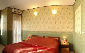 Un dormitorio con una cama roja con un arco rojo. en Ambaritsa Hotel, en Gorna Oryakhovitsa