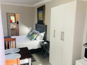 Un dormitorio con una cama, una mesa y una silla. en Baylight Accomodation Room 2, en Mossel Bay 2 fotos más