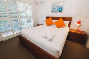 a bed with a white bedspread and pillows in a room at Sanctuary Lake Apartments in Gold Coast