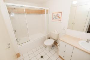 a bathroom with a toilet, sink, and bathtub at Sanctuary Lake Apartments in Gold Coast