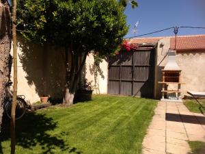 un patio trasero con una puerta y un patio de césped en Casa Rural Las Barricas en Coca