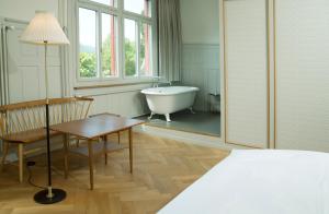Schlafzimmer mit Badewanne, Tisch und Bett in der Unterkunft Militärkantine St. Gallen in St. Gallen