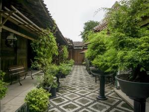 a courtyard with potted plants and a bench at RedDoorz Syariah @ Lempuyangan in Yogyakarta