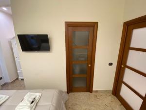 Zimmer mit einem Bett und einem TV an der Wand in der Unterkunft B&B San Michele Foggia in Foggia