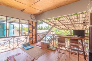 a room with a balcony with a desk and a television at Sor Vorapin Muay Thai Home in Bangkok