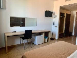 a bedroom with a desk with a chair and a mirror at Hotel Riverside in Modena