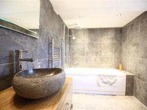 a bathroom with a large rock sink on a counter at The Cottage in Saint Briavels +25 photos
