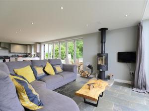 a living room with a couch and a wood stove at The Cottage in Saint Briavels