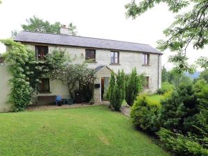 a white brick house with a yard with a yard at The Cottage in Saint Briavels