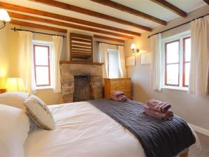 a bedroom with a large bed with two towels on it at The Cottage in Saint Briavels