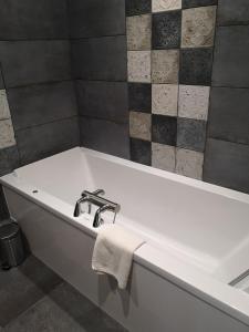 a bathroom with a bath tub with a towel on it at Villa Augeval Hôtel de charme & Spa in Deauville