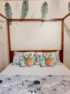 een bed met drie ananaskussens erop bij StayPlus Metro Manila Solano Hills Tropical Home Suite in Manilla