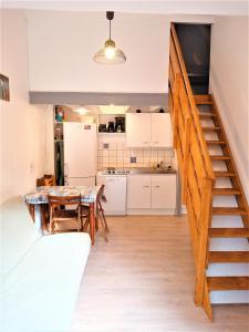 a kitchen and dining room with a staircase in a house at A Deux Pas du Courant in Mimizan-Plage