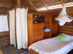 a bedroom with a bed in a wooden cabin at Longo Vezo in Anakao +51 photos