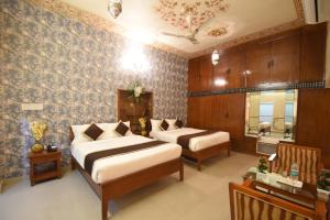 a hotel room with two beds and a mirror at Virasat Mahal Heritage Hotel in Jaipur