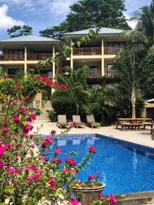 un complejo con piscina y algunas flores en Eden Hills Residence, en Anse Boileau