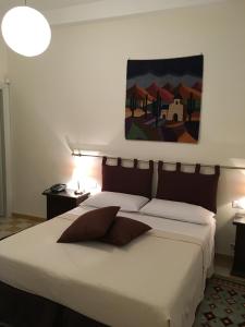 パレルモにある301B&Bのベッドルーム1室(壁に絵画が描かれた白い大型ベッド1台付)
