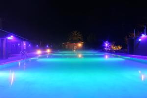 a swimming pool at night with blue lights at Amis Droles in Kawazu