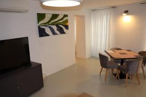 a dining room with a table and chairs and a television at Apartment Adriatico Eterno 2 in Rovinj