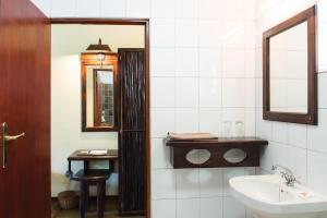 ein Bad mit einem Waschbecken und einem Spiegel in der Unterkunft Hippo Hollow Country Estate in Hazyview
