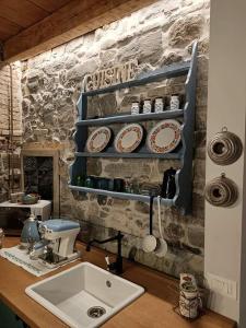 a kitchen with a sink and some plates on a wall at 1848 Chef's Rooms in Gorizia