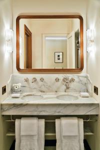a white towel hanging on the side of a white bed at Splendido Mare, A Belmond Hotel, Portofino in Portofino