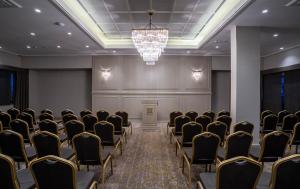 a room with rows of chairs and a chandelier at Hotel Kaleli in Gaziantep
