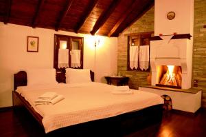 a bedroom with a bed with a fireplace in it at Traditional Guesthouse Lanari in Livádion