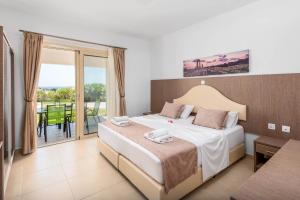 a hotel room with a bed and a balcony at Kolymbia Village in Kolimbia