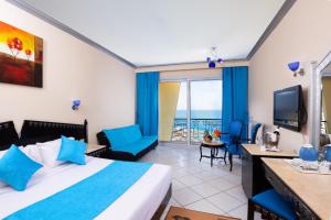 ein Hotelzimmer mit einem Bett und einem Balkon in der Unterkunft King Tut Aqua Park Beach Resort in Hurghada