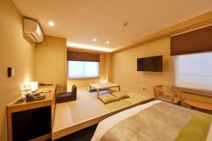 a hotel room with a bed and a tv at Rinn Shirakawa South in Kyoto